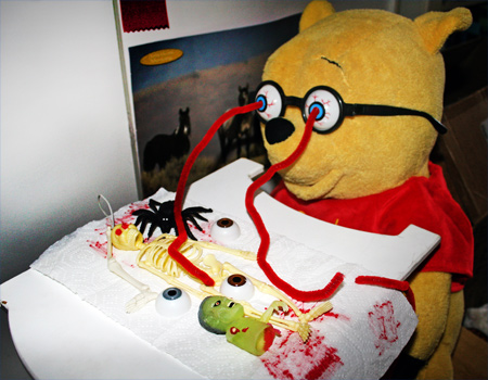 Winnie the Pooh, with bug eye glasses shooting blood on his meal of skeleton parts, pieces of zombie, spiders and eyeballs. Yummy!